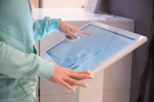 Faceless woman touching the screen of a self-service device in a store. Device store navigator. Self purchase